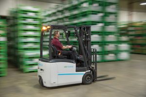 An employee operating the Unicarriers TX30 3 Wheel Forklift in a Beverage Warehouse