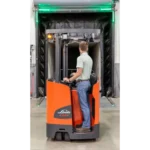 Thumbnail of http://A%20worker%20operating%20a%20linde%201346%20series%20stand%20up%20forklift