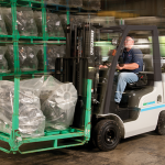 Thumbnail of http://A%20Warehouse%20Worker%20Carrying%20a%20Pallet%20of%20Engine%20Parts%20With%20a%20Unicarriers%20AF%20Series%20Propane%20Forklift%20Inside%20a%20Warehouse