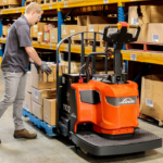 Thumbnail of http://A%20Worker%20Loading%20Boxes%20onto%20a%20Pallet%20on%20a%20Linde%20EWR%201101%20Series%20Rider%20Pallet%20Jack%20Inside%20a%20Warehouse