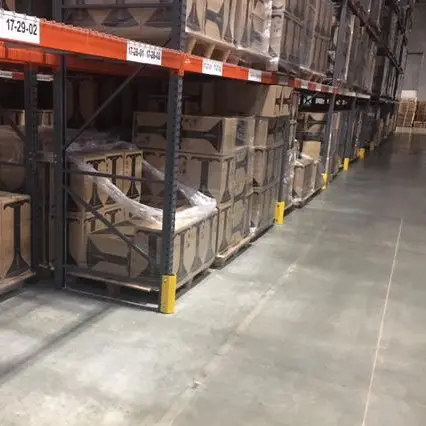 A Steel Bolt on Protector on a Row of Pallet Rack Uprights Inside a Warehouse